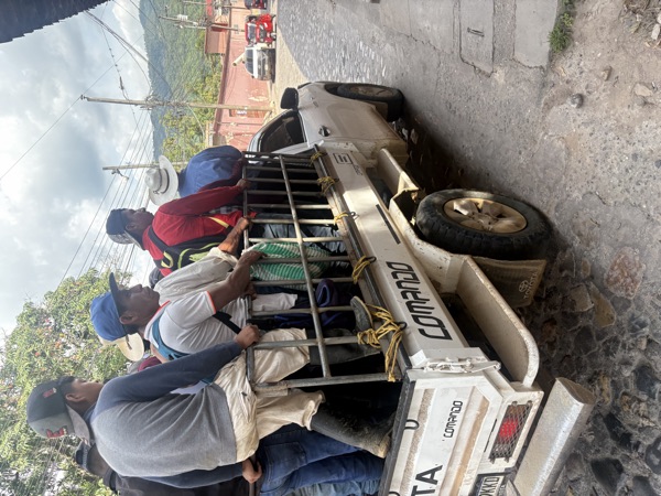 Men standing in the bed of a pickup truck
